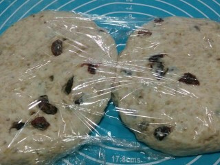 12、全麦核桃包～软欧包,用手轻轻拍打出面团里面的大起泡，包上保鲜膜松弛15-20分钟