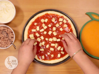 32、金枪鱼披萨，味道鲜美，馅料十足,抹平后摆放上马苏里拉芝士小块