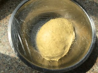 3、培根玉米粒披萨,盖上保鲜膜放到温暖处发酵。