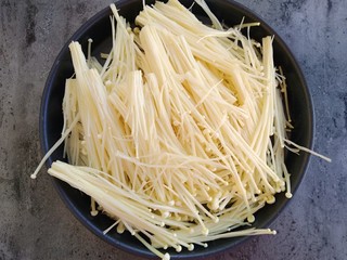 2、锡纸蒜蓉烤金针菇,将金针菇去头洗干净撕碎放入8寸披萨盘中