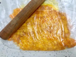 3、金沙奶黄馅的巧克力月饼,把蛋黄挑出来，放入食品袋里，用擀面杖擀碎。