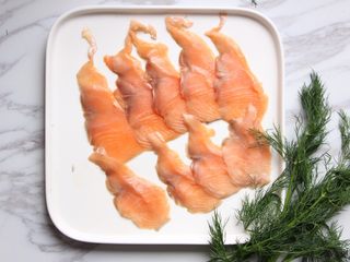 7、绿色美食+烟熏三文鱼牛油果沙拉,烟熏三文鱼先冻一下、然后斜片成薄片。片鱼时刀与鱼肉成30夹角，或外推或内拉，保持一个方向。我这个买来就片好了。