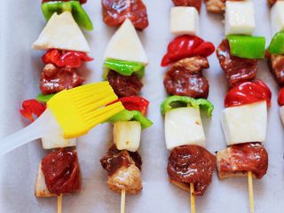 12、时蔬美味牛肉串,这个时候再用刷子蘸少许橄榄油，涂抹在牛肉串上。