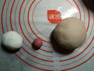 3、小猴汤圆,预留60克白面团,再取10克面团加入红曲粉揉成红色面团,余下的面团加入加入可可粉揉成棕色面团。用保鲜膜将这些面团盖住,防止表皮水分流失。
