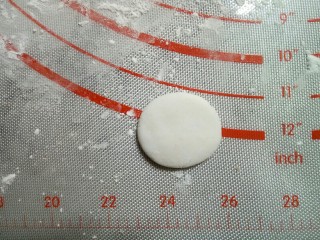 9、小猴汤圆,取约2克的白面团做猴子的脸部,揉圆,按扁。