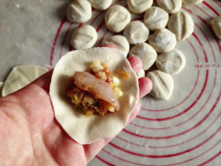 15、水饺,取一个面盘，把馅放在中间，再放上一个虾仁，包好，