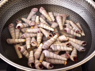 2、麻辣田螺,锅中倒入适量的清水，放入洗净的锥螺。