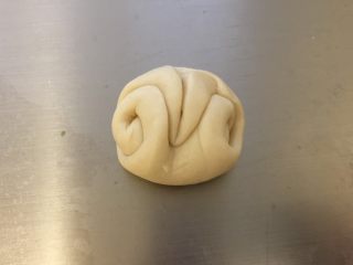 12、蛋黄酥,完成馅料后继续处理面皮：将刚才的卷卷收口朝上，用筷子在中间压一下，把两头往中间并拢。