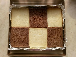 1、吐司披萨,烤盘里铺上锡纸，吐司片切成正方形(我用的山形吐司)放在锡纸上，可以用一种口味的吐司(我正好做了原味和可可味的就用了两种)