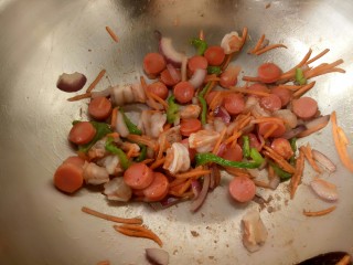 3、吐司披萨,大虾用大喜大烤肉酱腌一下，与其它配料入锅炒熟。(青椒，胡萝卜，洋葱每一样都留出一点一会做装饰)