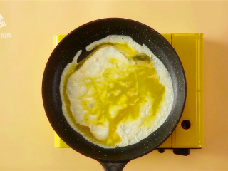 12、春游赏花便当，手残党也能轻松搞定,倒入第一碗蛋液，旋转平底锅摊成蛋饼