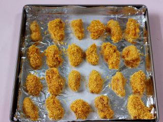 12、少油减脂的劲爆鸡米花,做好鸡胸肉放在垫有锡纸的烤盘，静置10分钟，这样面包糠就会和鸡块融入在一起，不会掉渣渣了。