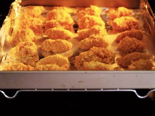 13、少油减脂的劲爆鸡米花,烤箱提前预热后，把烤盘入烤箱的中层。