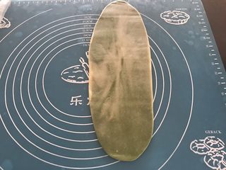 11、抹茶紫薯蛋黄酥,取第一个包好的面团，收口朝上擀成长舌形，