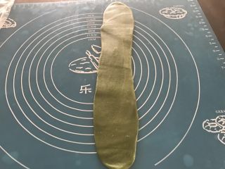 14、抹茶紫薯蛋黄酥,再次取第一个卷好的面团，再次擀成长舌状，比第一次擀的要窄一些
