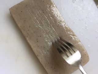 11、日式味噌煮九转小肠,炖煮小肠的同时，准备其他食材。用叉子在魔芋豆腐上横着竖着滑出痕迹。