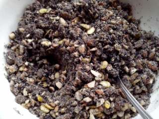 4、五仁月饼,将糯米粉和黑芝麻粉还有白糖还有20克油到进去搅拌均匀,如果觉得干就适当放点水,不要放多了,能捏成团就行。