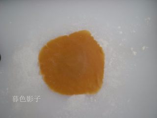 13、广式蛋黄月饼,取一个面皮,面案上撒点干粉,擀压成面皮