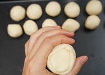 4、鲜肉月饼,取一份油皮，压扁，包入一份油酥，收口捏紧。