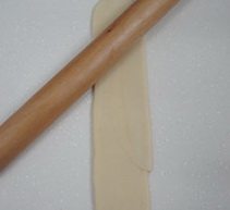 8、鲜肉月饼,再将卷筒按扁，擀成长条，然后再卷起来，收口朝下，盖保鲜膜再松弛10分钟。