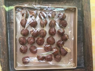 12、广式蛋黄红豆沙月饼,滚成球形，然后将包好咸蛋黄的红豆沙盖上保鲜膜