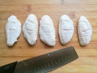 2、薯片鸡翅,捞出后，用刀在鸡翅的两面划上两刀，这样腌制的时候更容易入味。