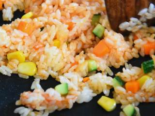 2、简易蛋包饭—黄金满兜的好运蛋包饭，你必须了解一下,放入米饭，加盐、番茄酱，翻炒均匀。