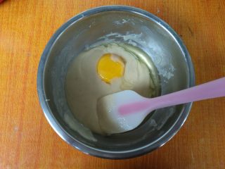 6、日式棉花蛋糕,加入1个蛋黄,搅拌均匀。