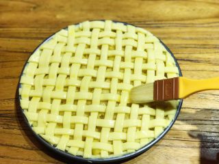 22、披萨模具也能做的酥皮苹果派,此时可预热烤箱，上下火200度15min。在编织好的派皮上刷上一层蛋液
