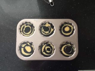 9、竹炭玛德琳,然后一勺原色面糊、一勺竹炭面糊交替倒入模具中，九分满。