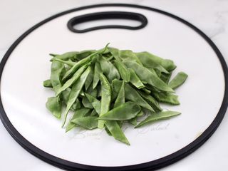 3、清爽营养的小炒鲜,眉豆两边去掉丝后洗净，每个眉豆用刀斜切两半