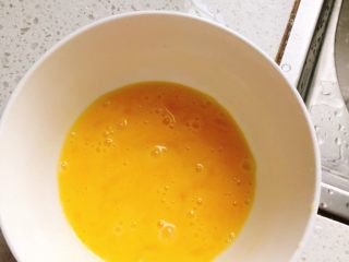 9、蛋包虾仁炒饭-宴请菜之主食,取1个鸡蛋，打入碗中，并用筷子搅拌使蛋黄与蛋白融合。