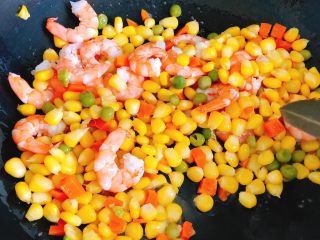 13、蛋包虾仁炒饭-宴请菜之主食,将什锦豆、虾仁倒入煎完蛋还满满是油的锅，翻炒2分钟炒香。