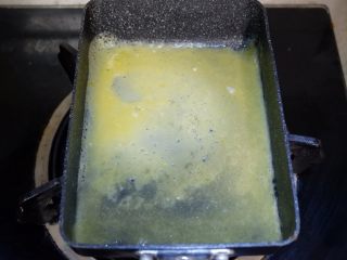 8、卡通面包超人便当「10」,倒入1/3的蛋液，等蛋液凝固至9成的时候，由上至下卷起来。