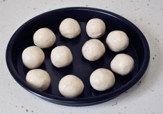 9、微甜不腻的红枣黑芝麻汤圆,用手将汤圆皮捏成圆形扁片，中间放上馅球，包紧滚圆即可。