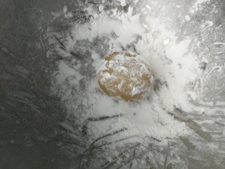 9、广式莲蓉蛋黄月饼,盆子里倒入玉米淀粉做手粉防粘，包好的月饼团成椭圆形放入玉米淀粉里滚一圈，轻轻拍去多余的粉