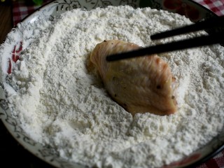 6、辣酱炸鸡,将腌制好的鸡翅、翅根裹上炸鸡粉