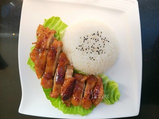 14、照烧鸡腿饭,米饭倒扣在盘子里。表面撒黑芝麻。鸡肉取出切长条，摆在米饭旁边。底下可以铺生菜，也可以不铺。