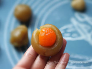 11、广式椰蓉月饼,手掌上沾少许面粉，取一个饼皮面团，在手掌上压扁；把椰蓉馅放在面团中间，用手把饼皮慢慢往上推，包裹住椰蓉馅