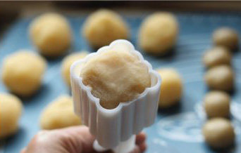 12、广式椰蓉月饼,直到把椰蓉完全包裹住，用手搓成略小于月饼模内径的圆柱体，在面团表面拍上少许面粉，将圆柱形面团放进月饼模内