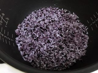 2、香甜菠萝糯米饭,把浸泡好的糯米和黑米一起倒入电饭煲内,加入适量的清水,比平时煮米饭的水量少一点即可,凭自己的经验掌握。