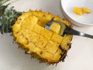 6、香甜菠萝糯米饭,用小汤勺把菠萝果肉挖出来。