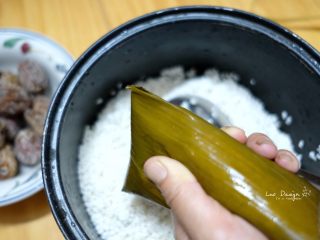 4、蜜枣白米甜粽,顶部多余的粽叶折叠握紧。