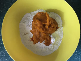 2、南瓜豆沙汤圆,用勺子舀出南瓜泥放微波炉叮2分钟，趁热倒入糯米粉中，用筷子搅匀成颗粒状；再根据面团的干湿情况，分次加入110克室温的水，边加边搅拌均匀