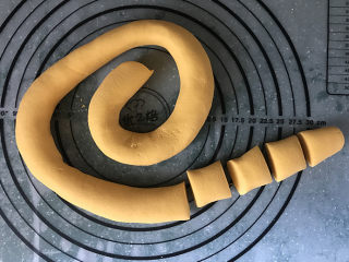 6、南瓜豆沙汤圆,然后搓成长条，切成大小均匀的剂子，盖上保鲜膜以防面团水分流失