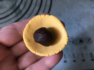7、南瓜豆沙汤圆,取一个小剂子按成小窝状，中间放上豆沙球