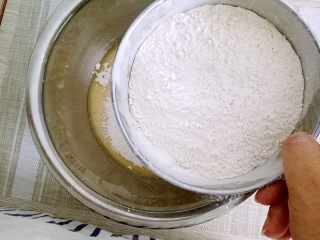 5、月饼#小胖手作，送礼更要送健康#,面粉过筛筛到打好的糖浆里面