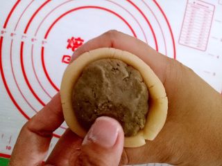 9、月饼#小胖手作，送礼更要送健康#,我烤了一些面粉，用来防粘连，手上沾些熟面粉把饼皮压扁，包上豆沙馅，