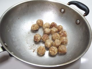 9、照烧小丸子,锅烧热，放入一大匙油，加入沾粉的丸子用小火煎至表面金黄色，盛出备用。