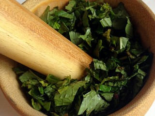 2、薄荷青团,洗净，切碎，放进蒜臼中，捣碎。（因为做的青团不多，我用了古法取汁。做的多的亲们果断用料理机打汁）